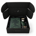 Open black Discovery Reads book subscription box with books and a candle on a white background